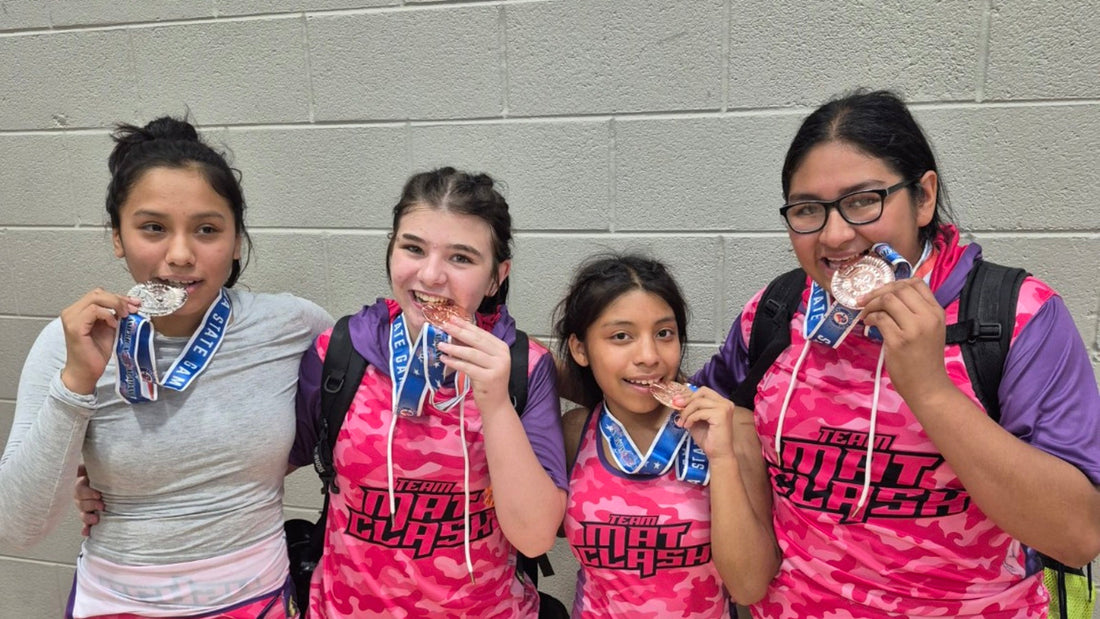 Young wrestlers wearing custom Team MAT CLASH gear with their medals